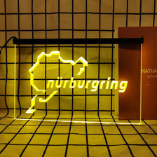 A neon sign shaped like the state of Nuremberg in bright yellow light against a grid background.