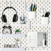 A wall-mounted pegboard organizer featuring various hooks and white storage boxes for tools and accessories.