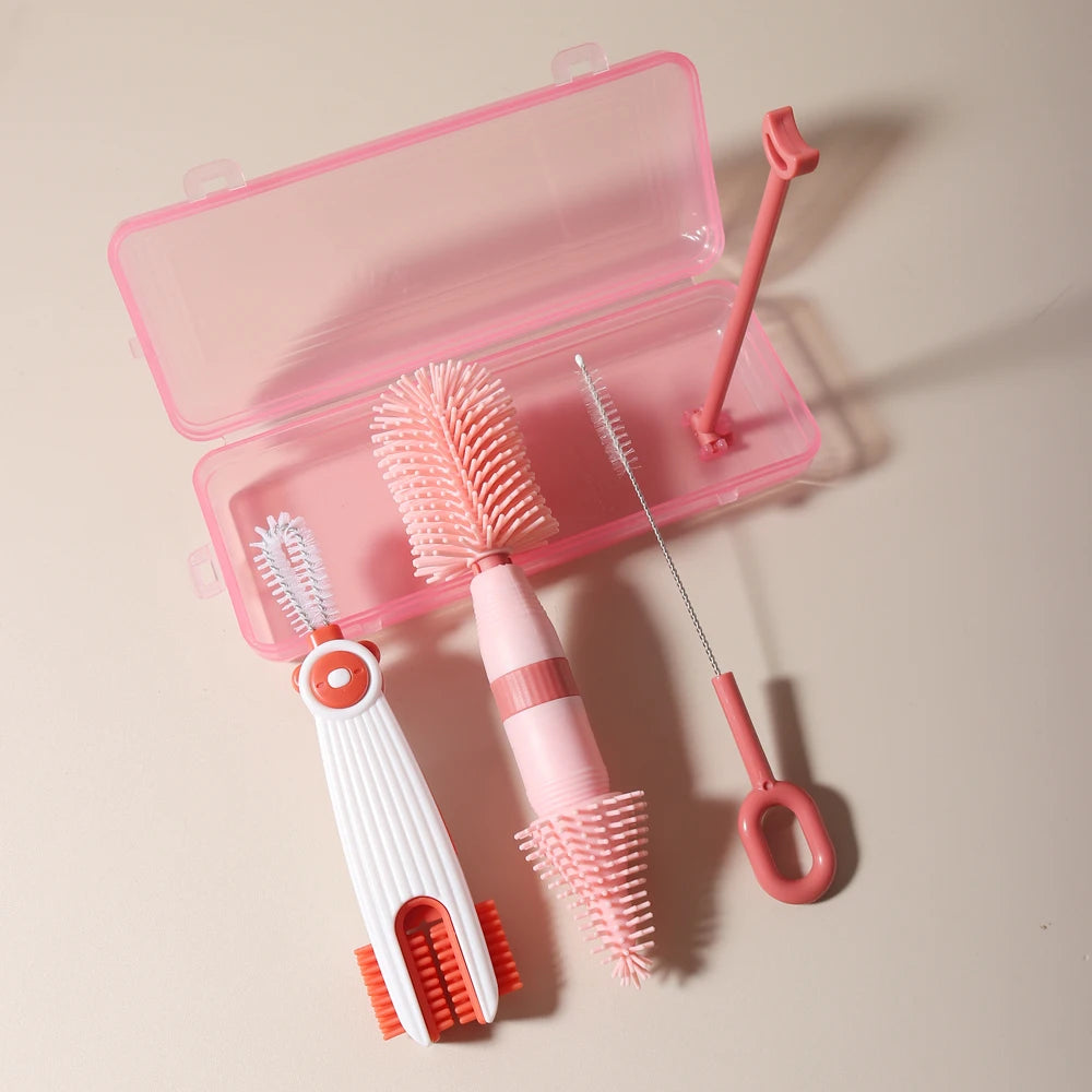 A pink silicone baby bottle cleaning set featuring a brush, a bottle brush, and a silicone cleaning tool.