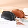 A brown PU leather key organizer wallet with a gold zipper is shown next to a black version on a white surface.