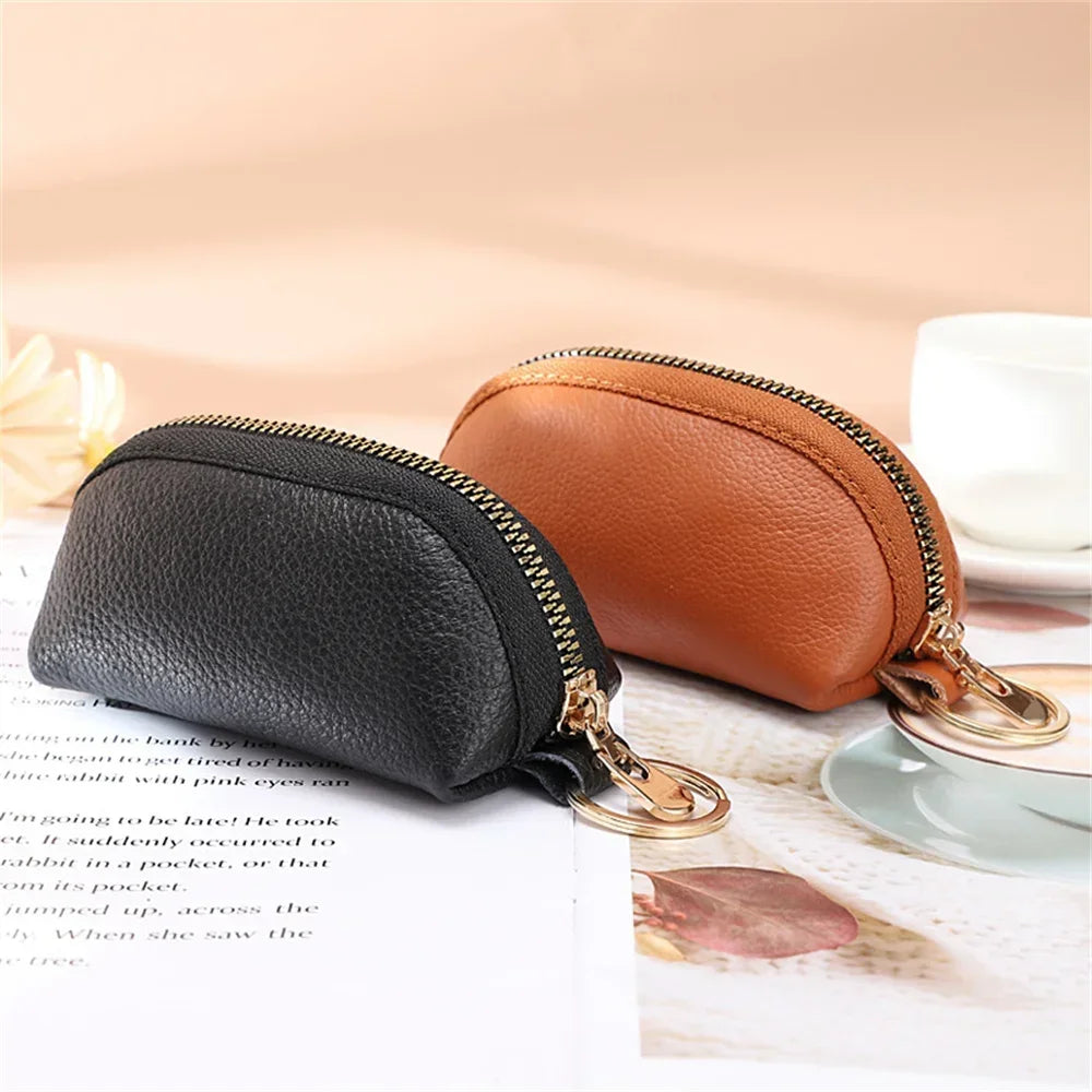 A brown PU leather key organizer wallet with a gold zipper is shown next to a black version on a white surface.