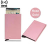 A pink slim metal RFID blocking card holder with a pop-up design, shown next to a gold card.