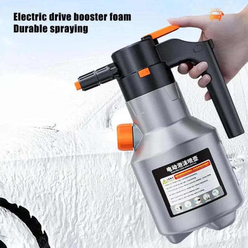 A hand is holding a black electric drive booster foam sprayer with an orange nozzle, ready for spraying.