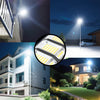 A close-up view of a 320° wide angle solar street light with motion sensor and remote, illuminating a dark outdoor scene.