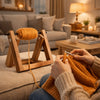 A person is using a rotating wooden yarn ball holder with a stable base to create knitted fabric.