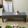 A gray waterproof PU stretch bench cover is placed on a wooden floor in a bright room.