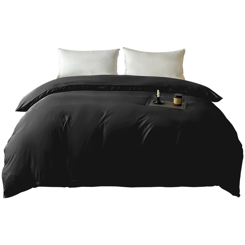 Black brushed duvet cover with white pillows and a candle on the bed