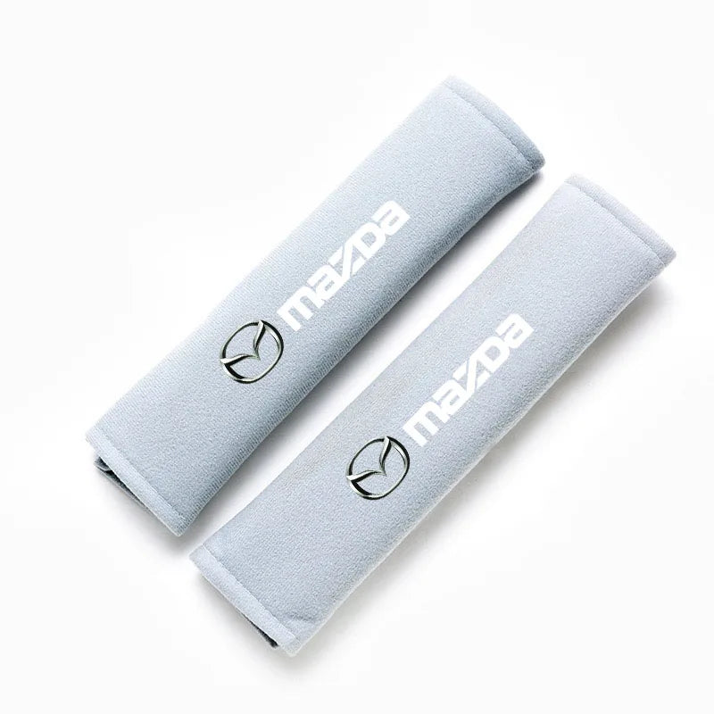 A light gray soft cotton car seat belt shoulder protector cover rolled up and displayed on a white background.