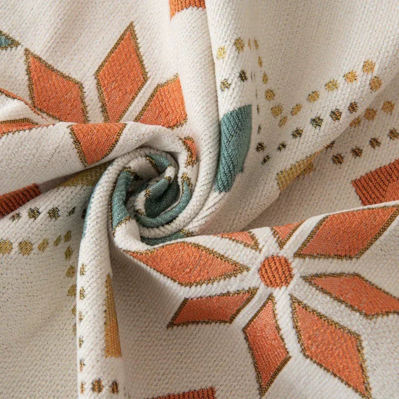 Close-up of a beige and terracotta patterned fabric, likely a sofa cover, showing a rolled texture.