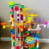 A colorful marble run with a motorized elevator and various track components for a STEM building set.
