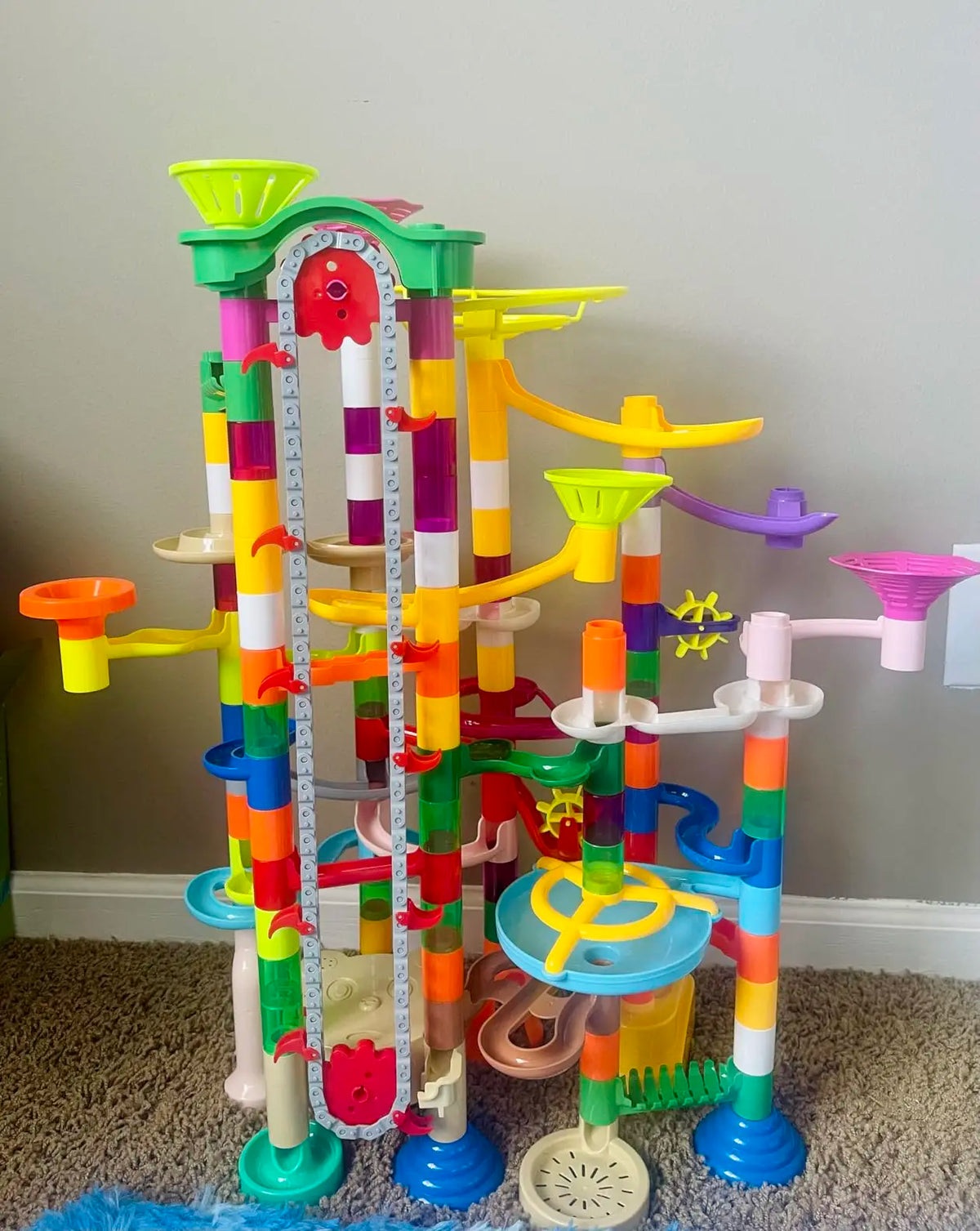 A colorful marble run with a motorized elevator and various track components for a STEM building set.