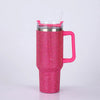 A pink rhinestone bling tumbler with a straw and handle is shown against a white background.