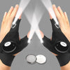 Pair of black waterproof LED half-finger gloves being used to illuminate a surface.