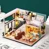 A detailed wooden dollhouse miniature building kit featuring furniture and interior scenes.