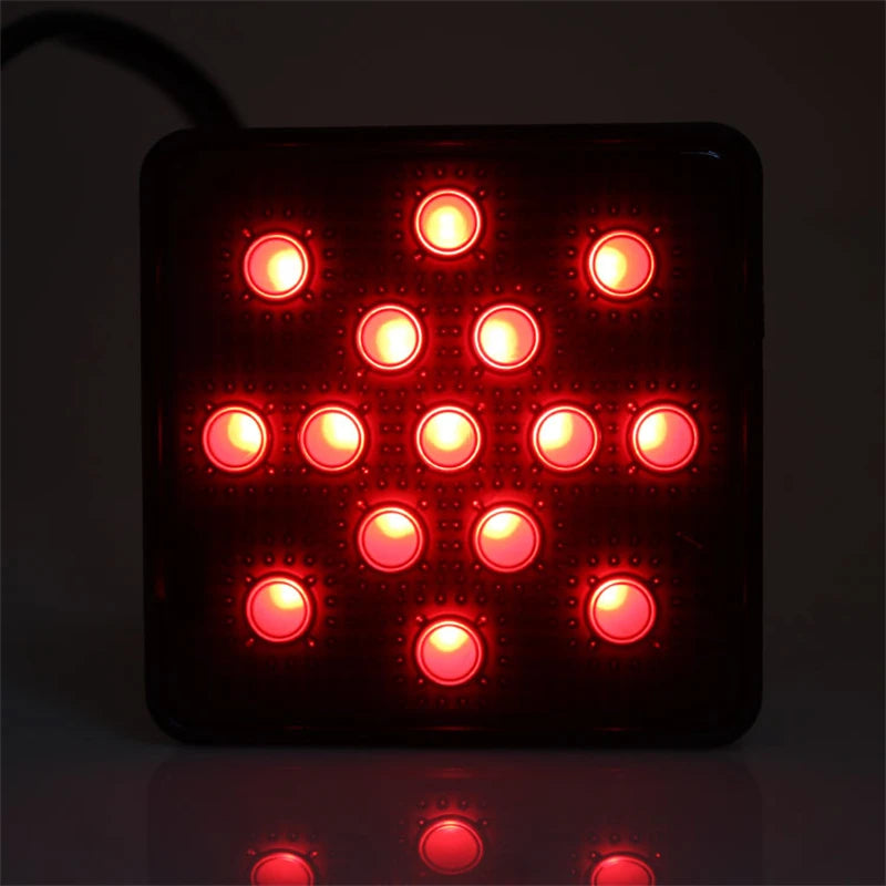 A black LED trailer tail light with multiple red circular lights illuminating the surface below.