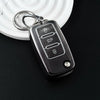 A silver key fob with a metal split ring attached, resting on a white surface.