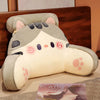 A light gray plush cushion shaped like a cat's head with pink accents, used as a backrest for furniture.