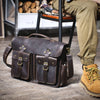 Dunkelbraunes Vintage-Ledertasche auf Holzoberfläche neben einem Bein.