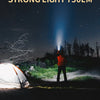 A strong light 750lm flashlight beam cuts through the night sky near a tent and trees.