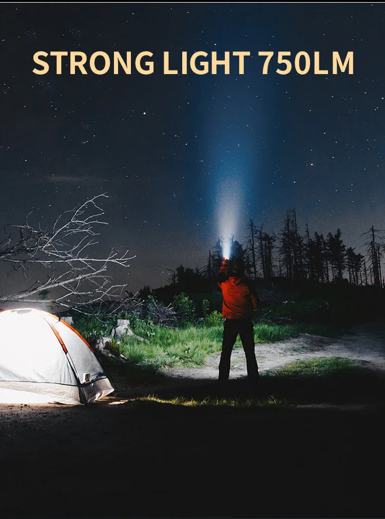 A strong light 750lm flashlight beam cuts through the night sky near a tent and trees.