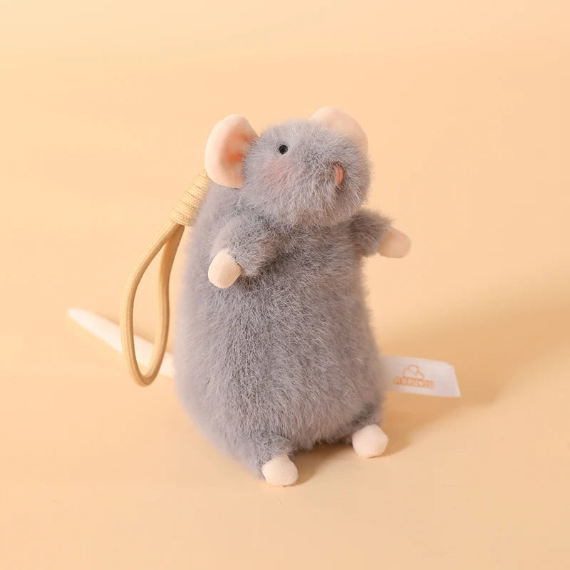 A soft gray plush mouse stuffed animal with a light pink ear and a yellow keychain loop.