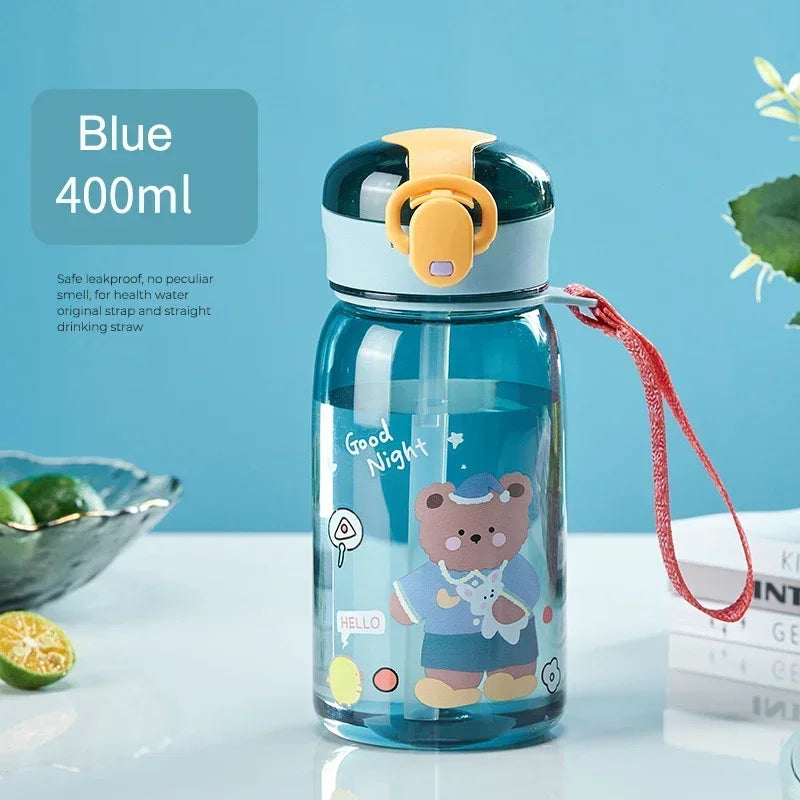 A blue 400ml kids cartoon straw water bottle with an orange leakproof lid sitting on a white surface.