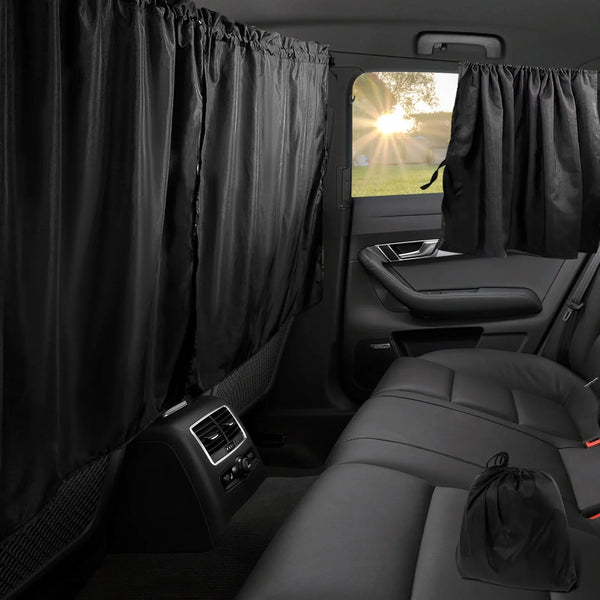 Black privacy curtains covering the rear window of a car, shown inside the vehicle cabin.