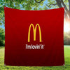 Une bannière rouge avec le logo des arches dorées de McDonald's et le texte "I'm lovin' it", affichée à l'extérieur.