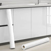 Roll of white pearl finish waterproof self-adhesive wallpaper next to a kitchen countertop.