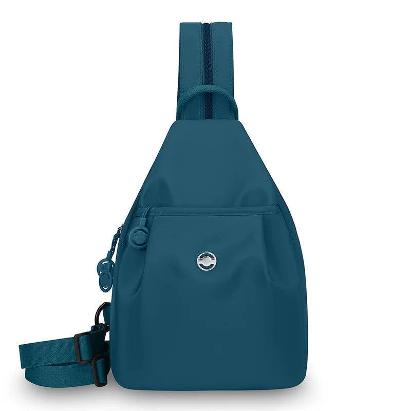A dark teal women's lightweight mini backpack with a strap and a silver logo.