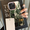 A pink monstera pattern phone case for an iPhone is shown in a black sleeve.