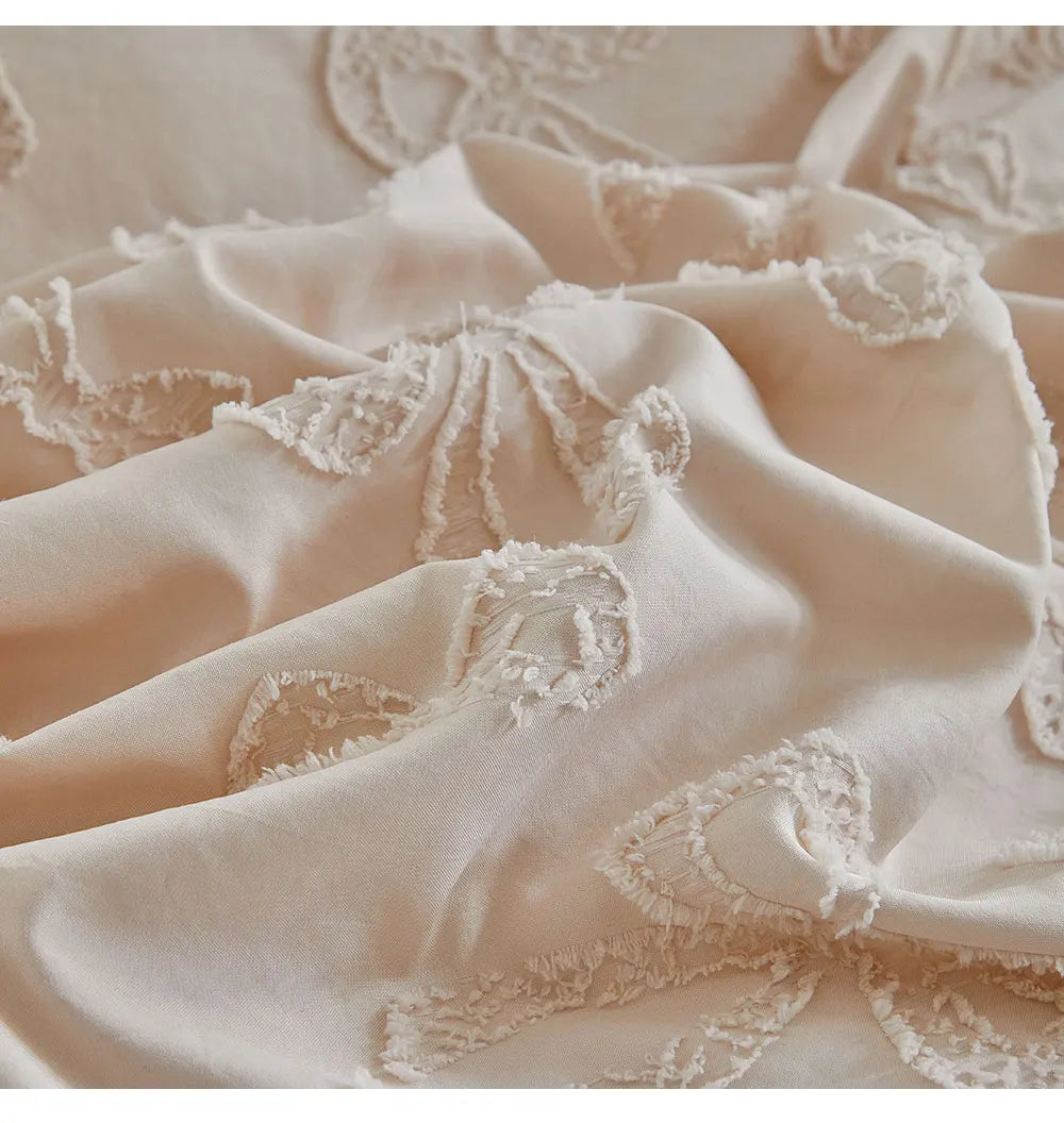 Close-up of a beige linen duvet cover featuring delicate white lace trim and folds.