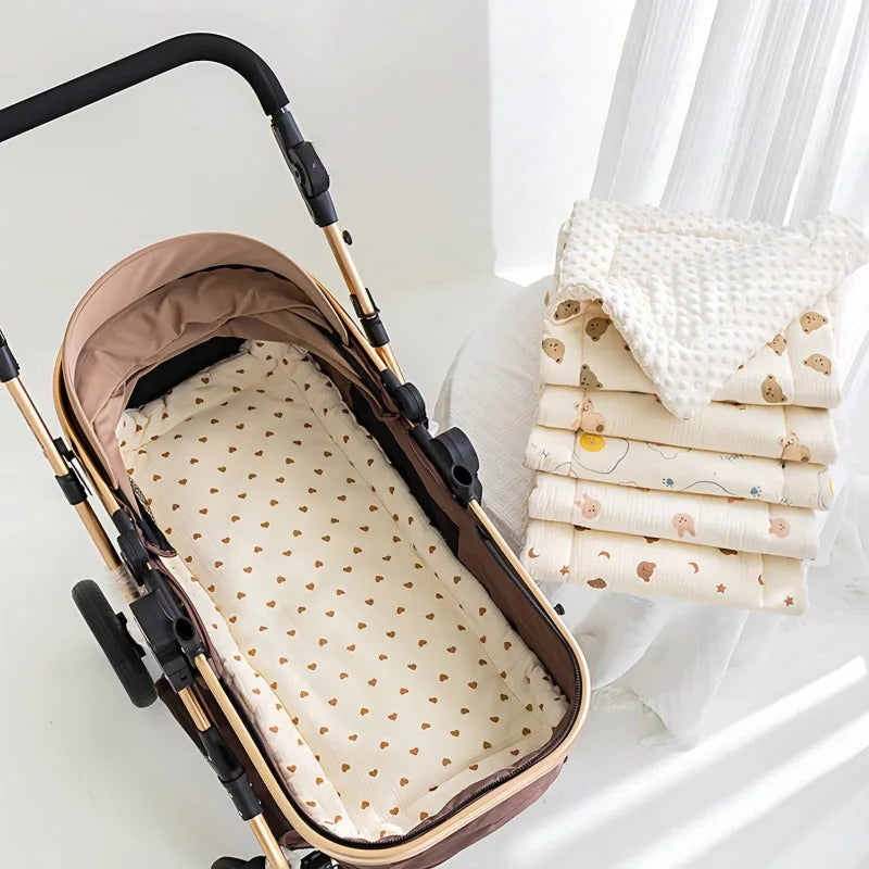 A beige baby stroller seat cushion with padded support is shown resting on a white surface.
