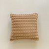 A rectangular, textured beige plush pillow cover with horizontal ribbing.