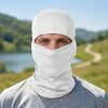 A man wearing a white stretchy breathable balaclava cap for outdoor sports against a scenic, green landscape.