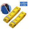 Yellow flexible measuring tape with dual scales marked in inches and centimeters, shown next to a person's torso.