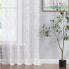 White vintage floral lace curtain panel filtering light in a window