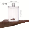 A hand holds a clear acrylic jar with a lid, designed to hold cotton balls or swabs.