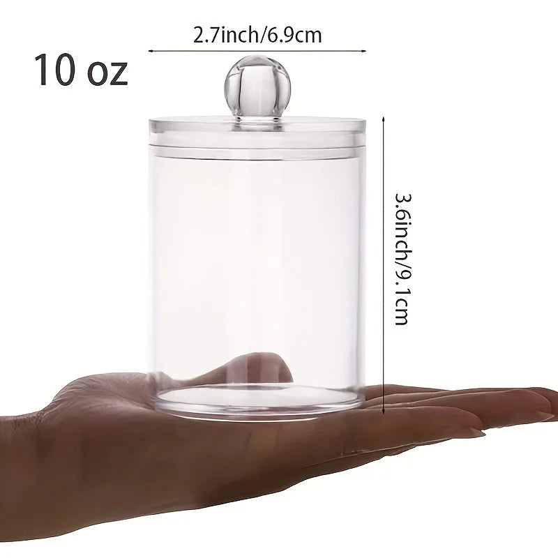 A hand holds a clear acrylic jar with a lid, designed to hold cotton balls or swabs.