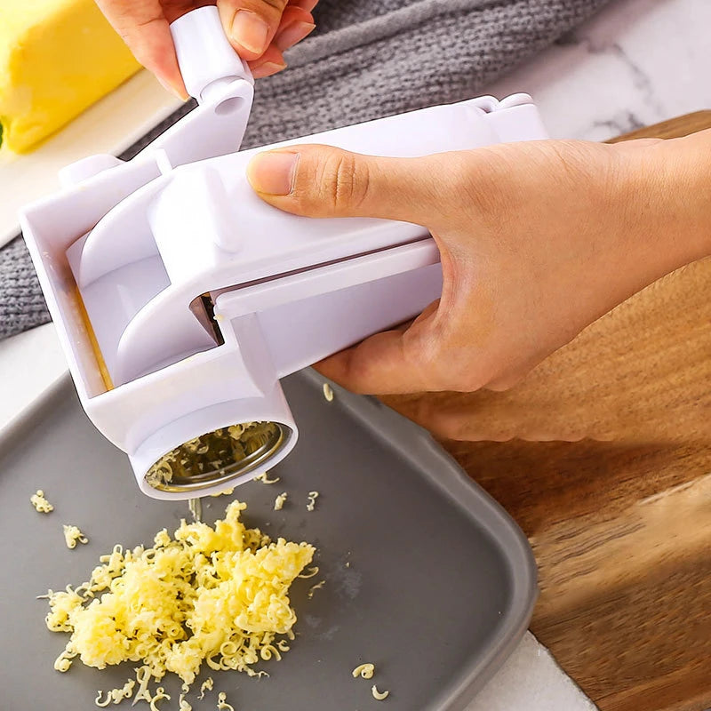 Une main utilise un râpe à fromage manuelle pour râper du fromage jaune sur une planche à découper grise.