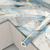 Marble contact paper featuring blue and gold veining used as a kitchen or bathroom surface design.