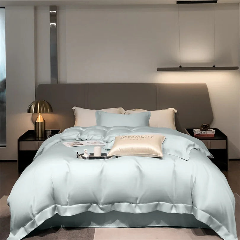 Helles blaues Luxus-Bambus-Bettwäsche-Set auf einem Bett mit grauem gepolstertem Kopfteil.