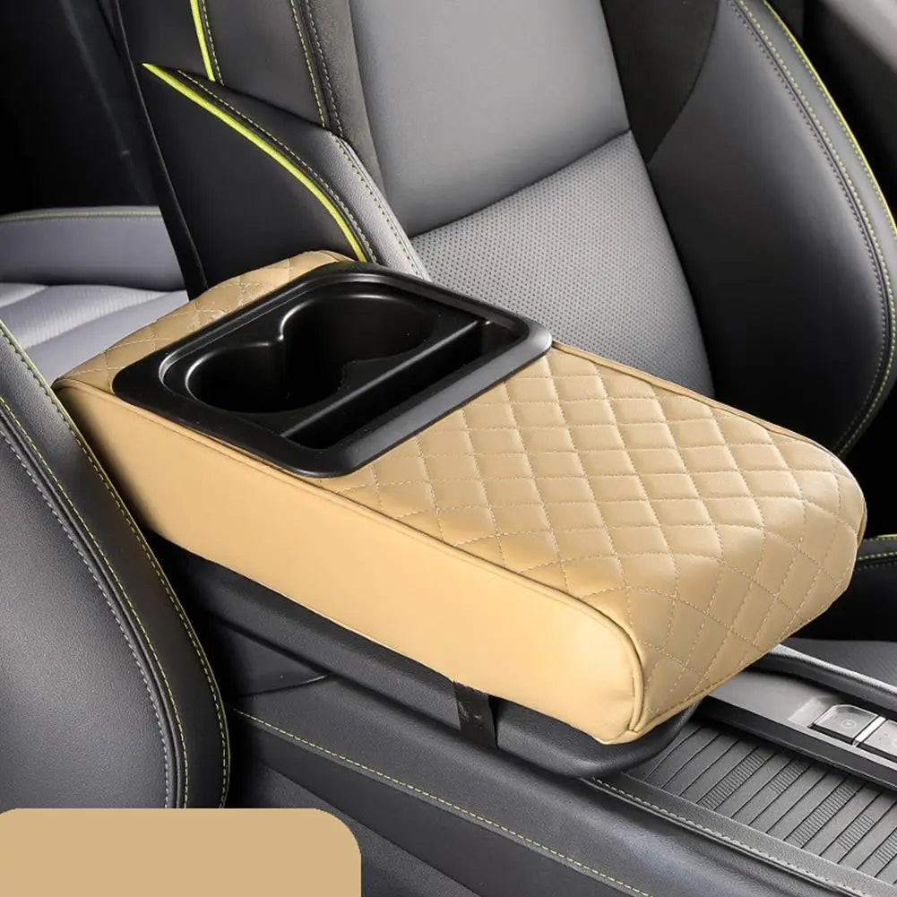A tan car center console armrest cushion with a black cup holder is shown in a gray and black car interior.
