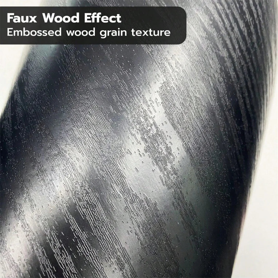 Close-up texture of faux wood effect film showing embossed wood grain in a dark gray finish.