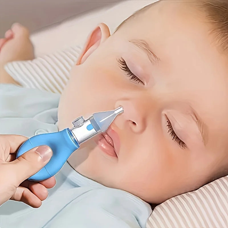 A baby is being gently aspirated from the nose using a blue nasal aspirator with a soft silicone tip.