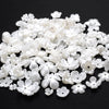 A pile of 100 white acrylic pearl spacer beads for jewelry making.