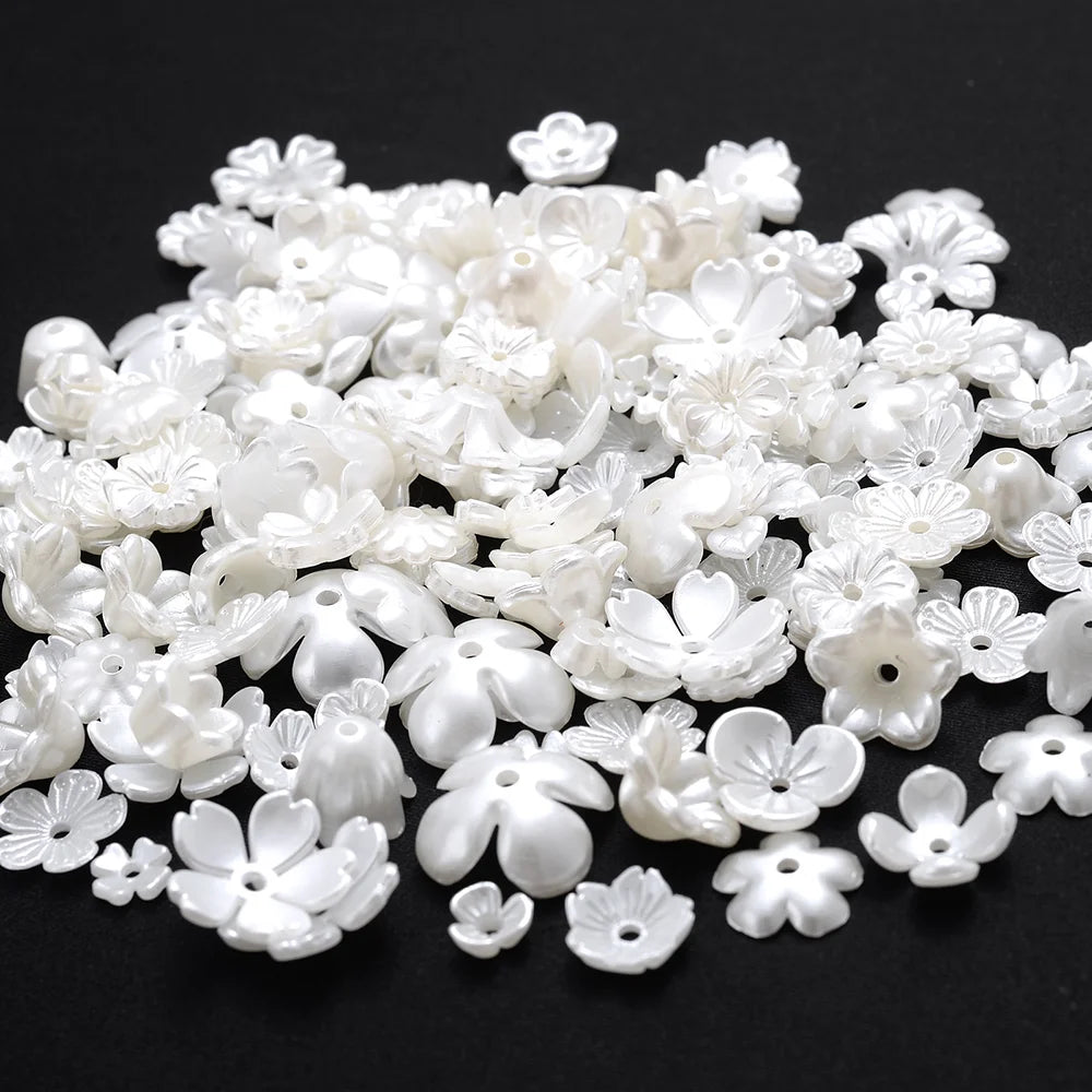 A pile of 100 white acrylic pearl spacer beads for jewelry making.