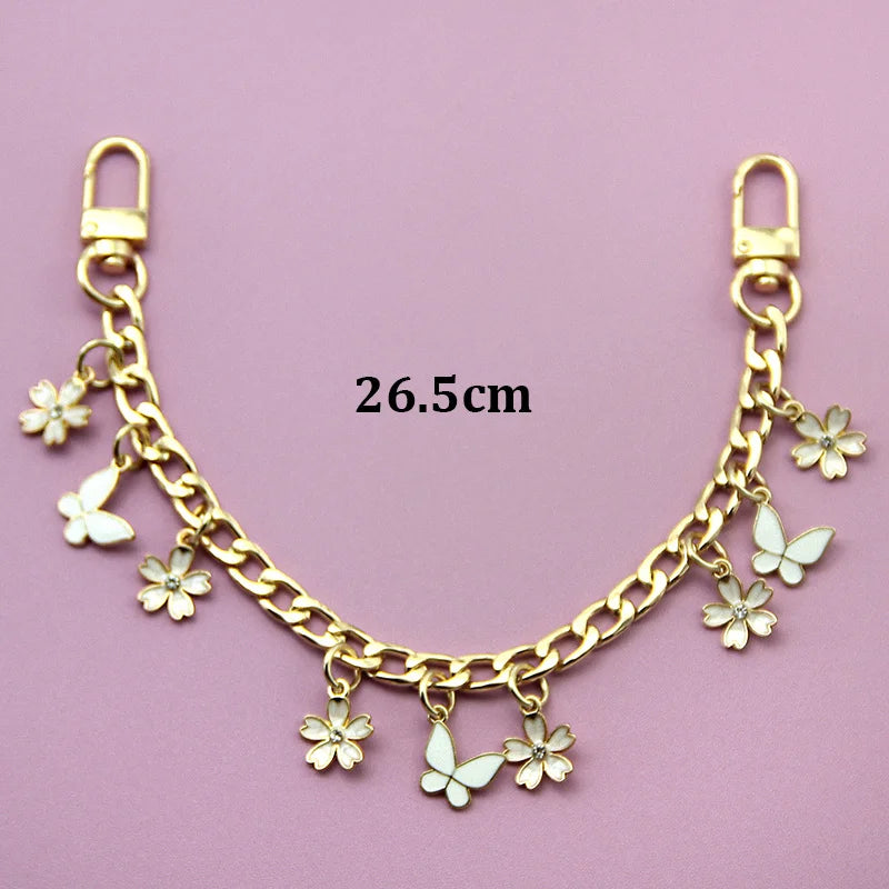 A gold-colored chain necklace featuring small white flower charms and a lobster clasp, measuring 26.5cm.
