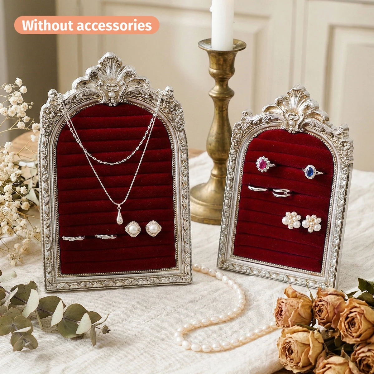 A display stand for jewelry featuring an arched resin frame with a floral design and velvet lining.