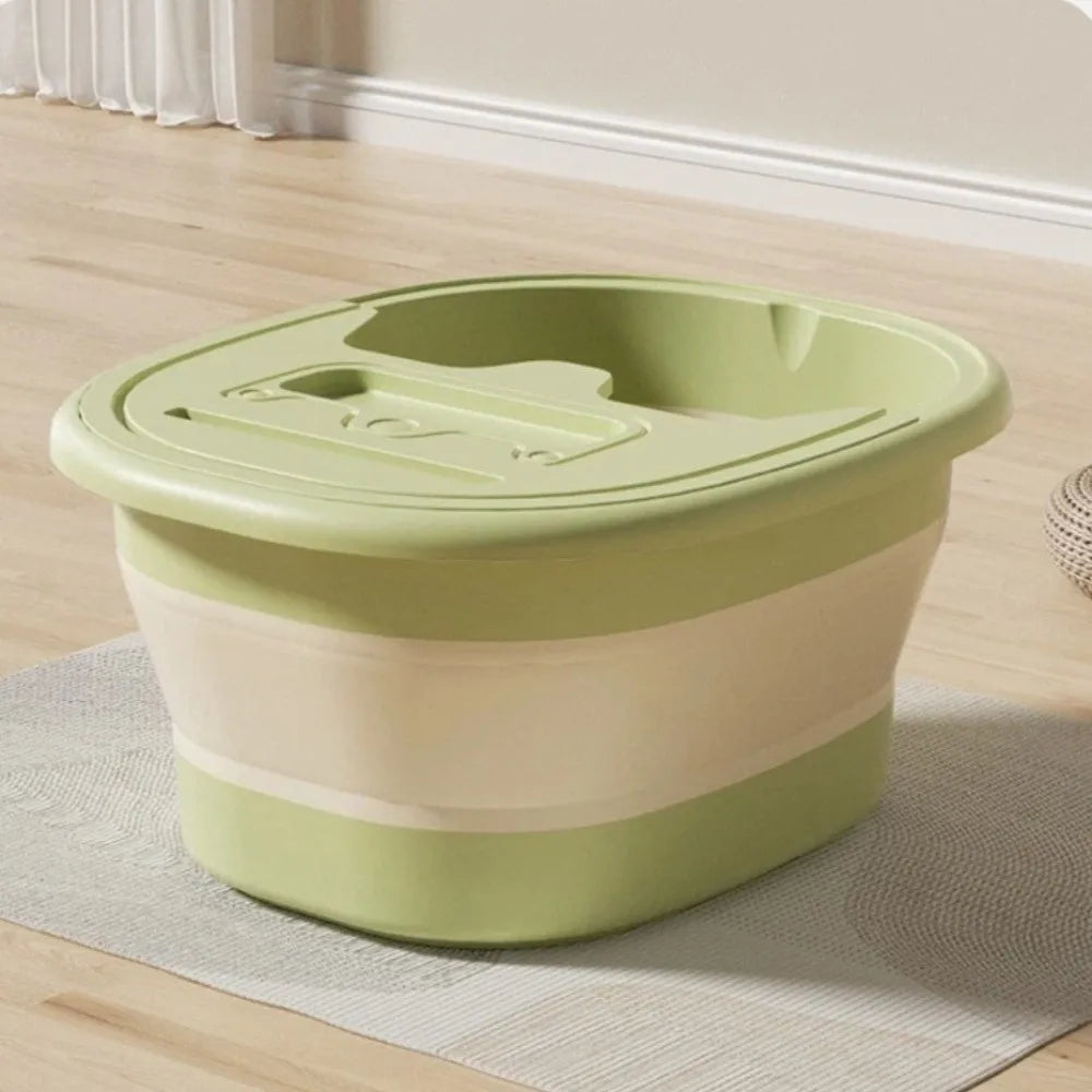 A light green foldable foot bath tub with a lid and striped accents resting on a light rug.